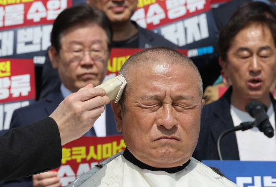 더불어민주당 윤재갑 해양수산특별위원회 위원장이 30일 오전 국회에서 열린 후쿠시마산 수산물 수입 반대 및 대일 굴욕외교 규탄대회에서 삭발식을 하고 있다.  연합뉴스